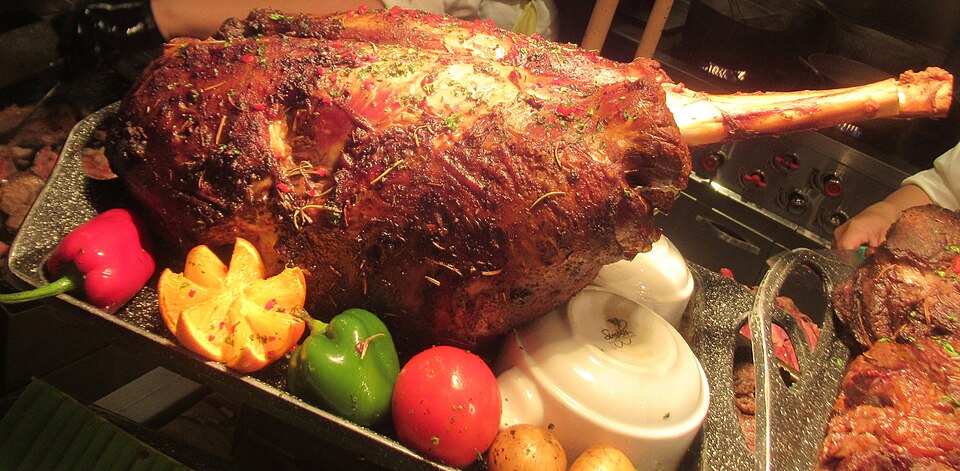 A whole roasted Greek arnaki lemonato lamb leg with lemon and herbs