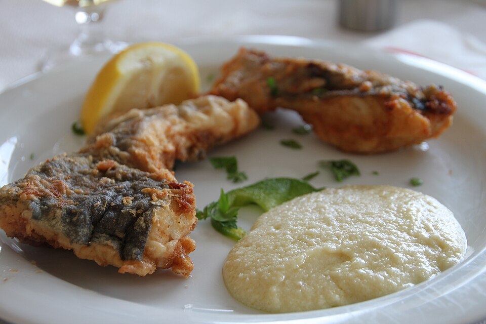 Fried Greek salt cod fillets served with a bowl of garlic potato skordalia