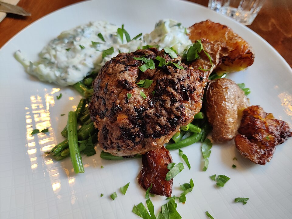 A Greek bifteki patty cut open showing melted feta inside