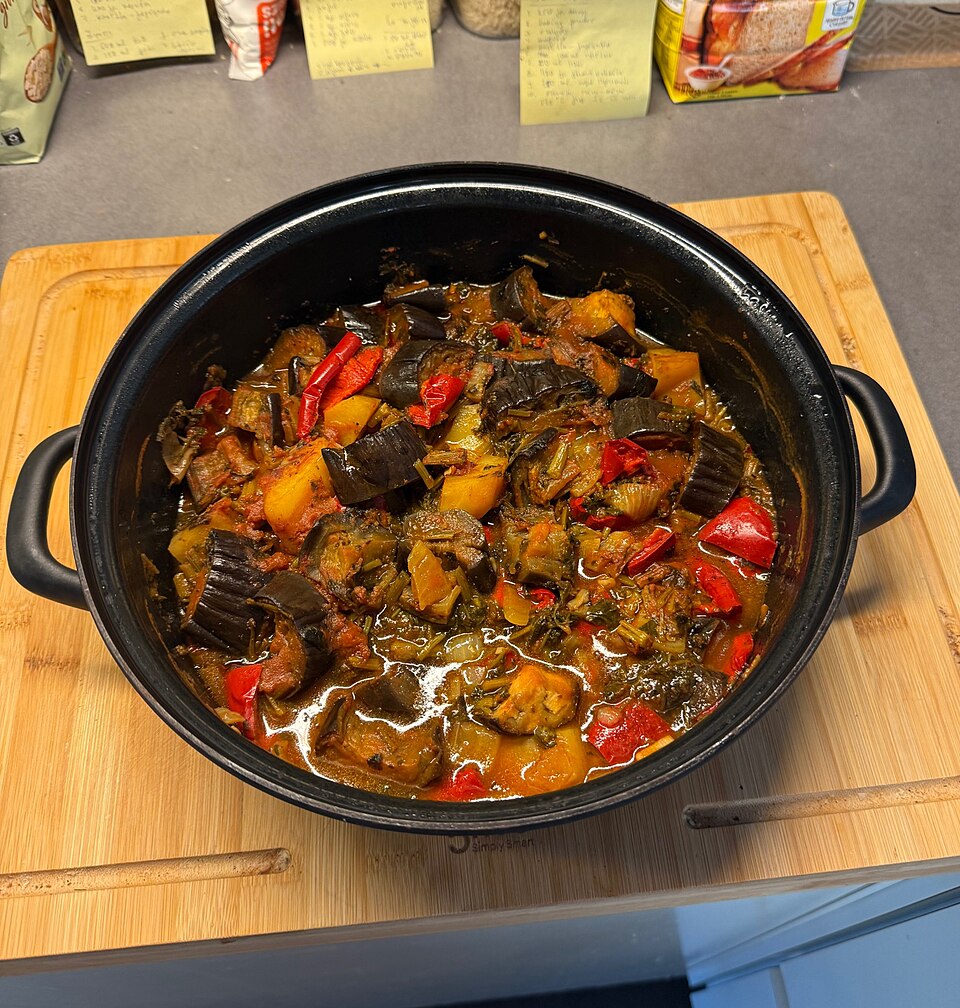 A tray of collapsed roasted Greek vegetables, browned at the edges and glossy with olive oil
