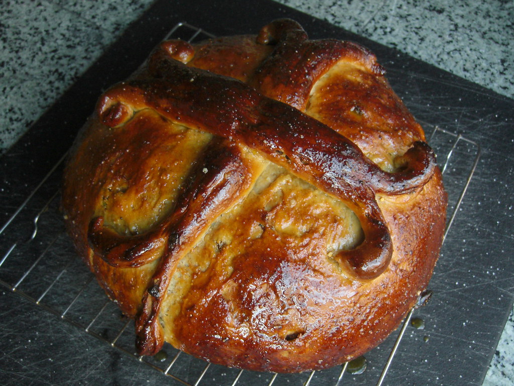 A round Greek Christopsomo Christmas bread with a decorative dough cross
