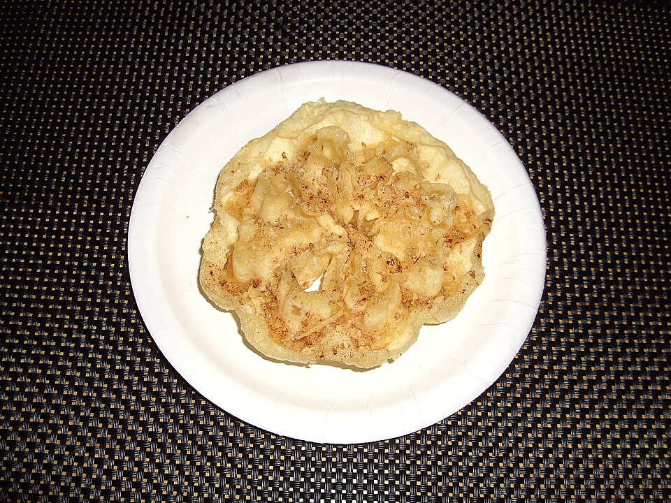 Curled crisp Greek diples pastry ribbons drenched in honey and walnuts