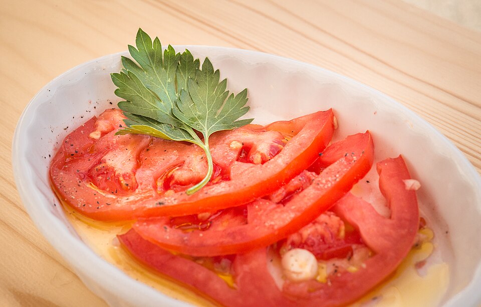 A plate of sliced Greek domatosalata tomato salad with oregano and olive oil