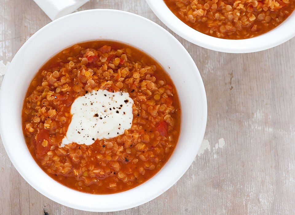 A bowl of Greek red lentil soup with cumin and a drizzle of olive oil