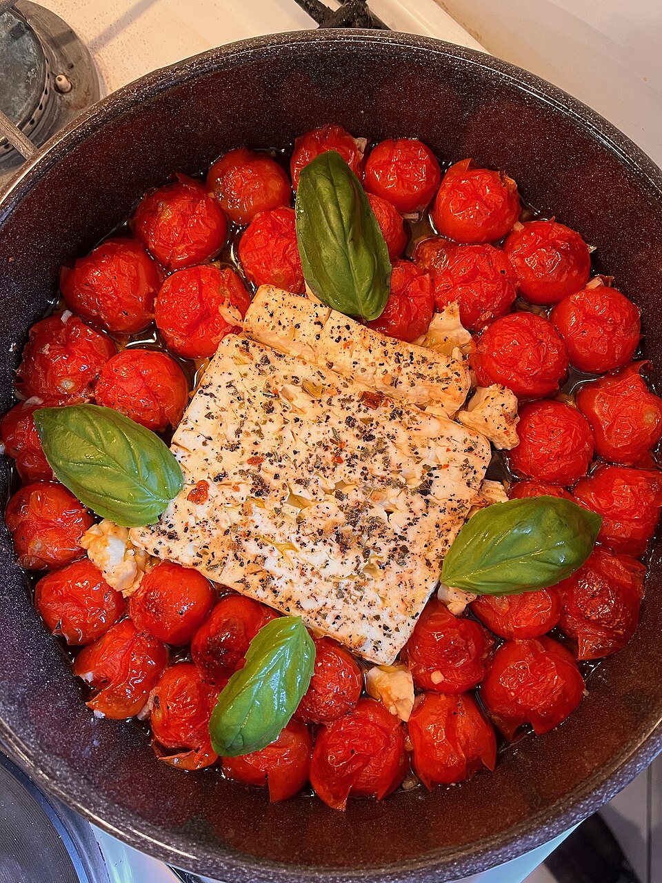 A dish of Greek feta psiti me ntomata baked feta with tomato