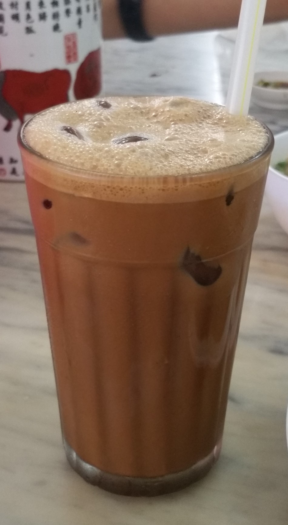 A glass of Greek freddo espresso iced coffee with a thick foam head