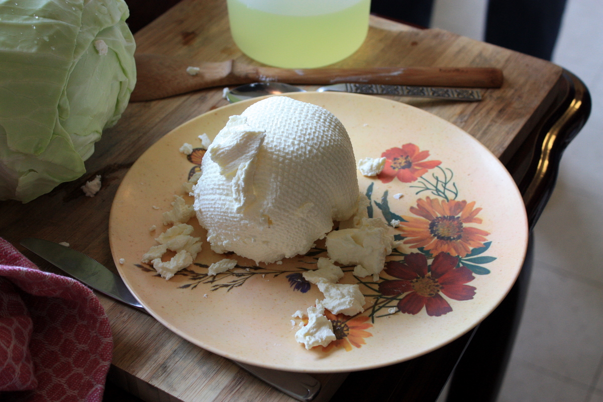 Yogurt straining through cloth over a bowl, whey collecting below