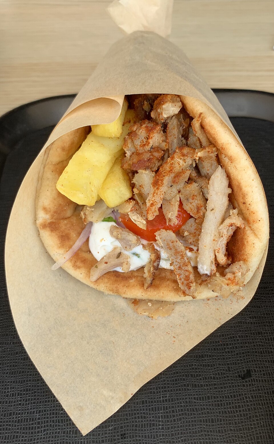 Thin strips of crisped pork gyros piled in a warm pita with tomato, onion and tzatziki