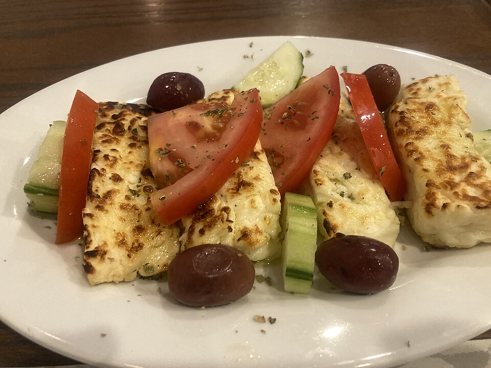 Golden grilled halloumi slices with lemon wedges and dried mint