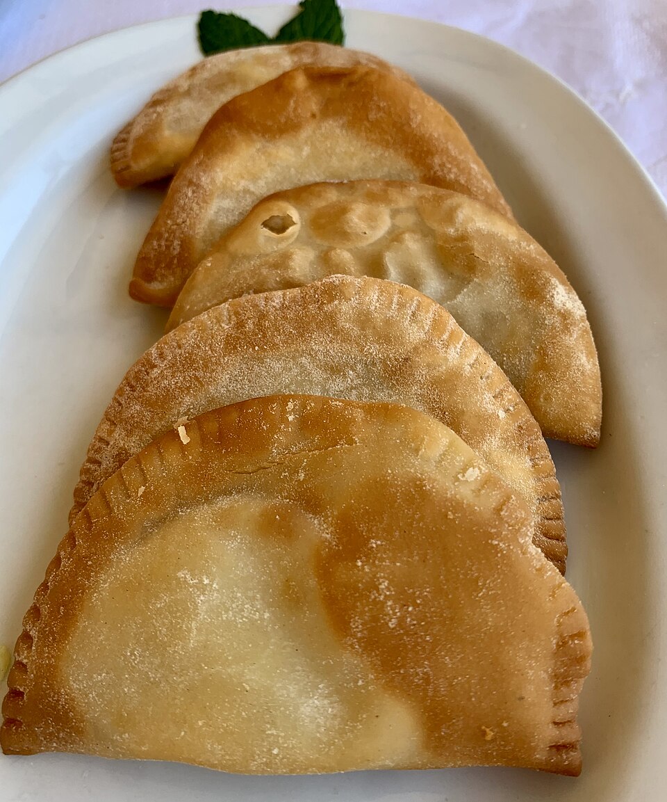 Golden Cretan kalitsounia cheese hand pies drizzled with honey
