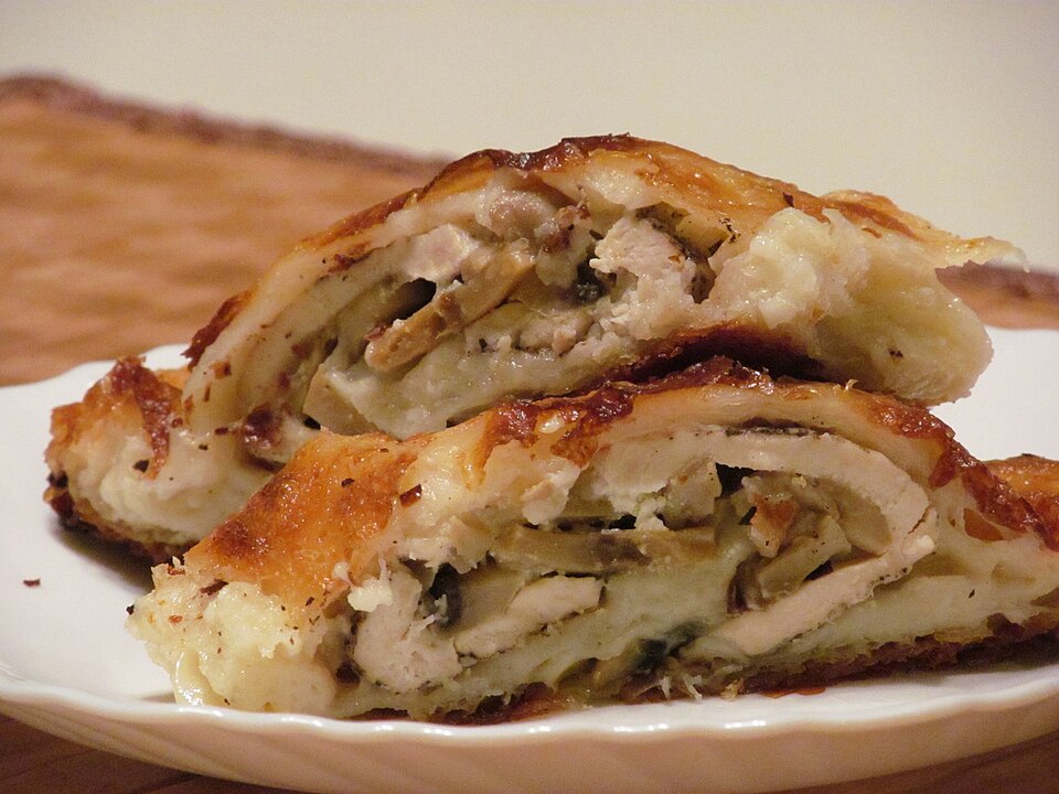 A slice of Greek kotopita chicken pie showing layered phyllo and filling