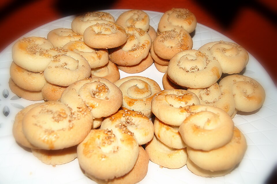 Twisted golden Greek koulourakia Easter cookies on a baking tray