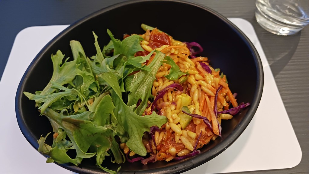 A bowl of Greek kritharosalata orzo pasta salad with tomato, feta and olives