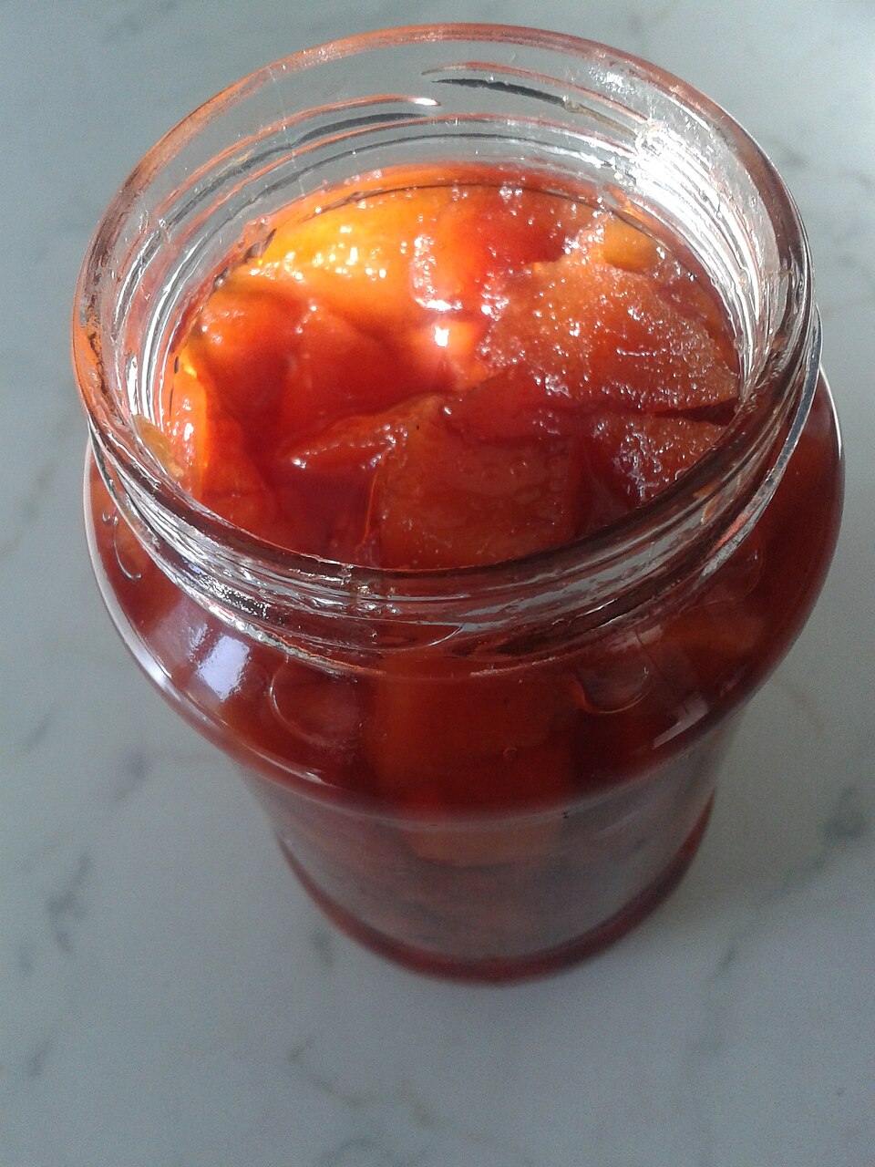 A jar of Greek kydoni glyko quince spoon sweet, deep amber red
