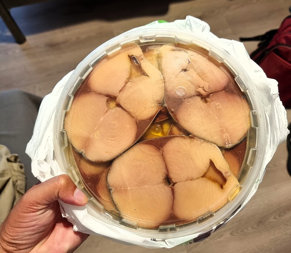 Slices of Greek lakerda, salt-cured bonito, with raw onion and olive oil