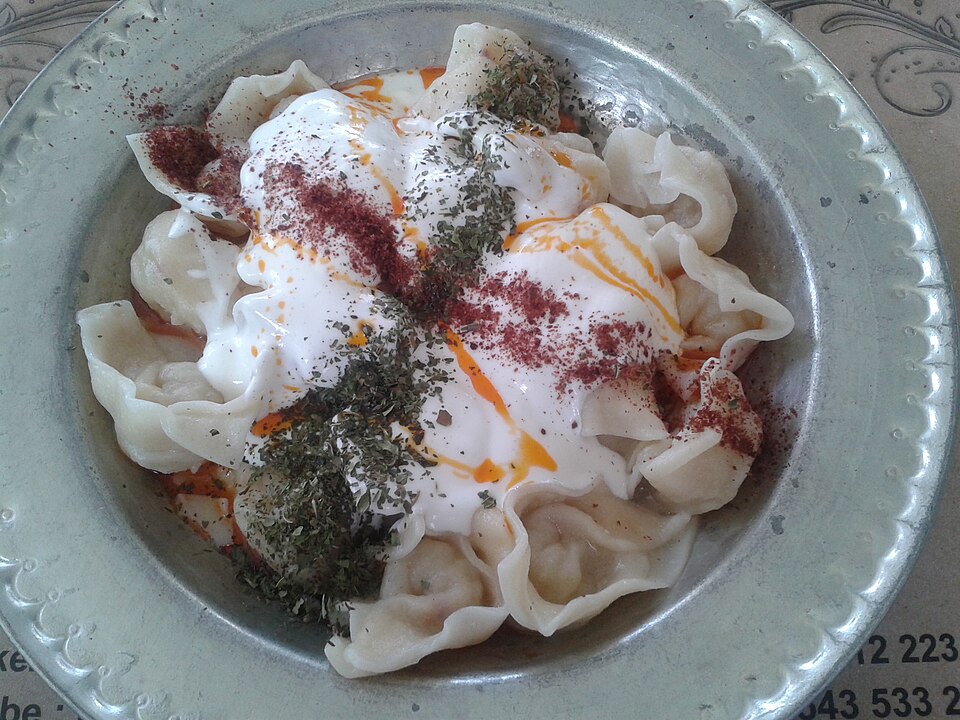 Pontic Greek manti dumplings served under garlic yogurt sauce