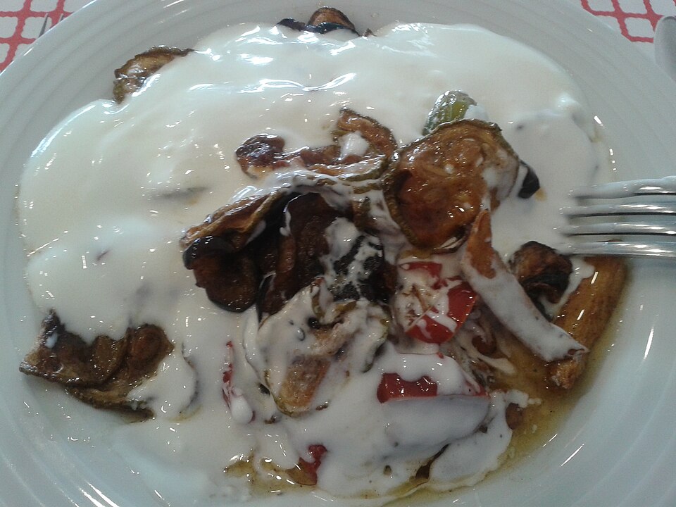 Fried aubergine slices topped with garlic yogurt and paprika butter