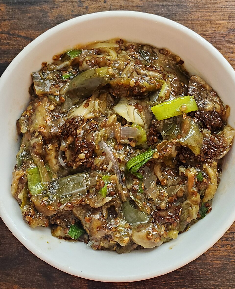 A bowl of smoky Greek melitzanosalata dip with charred aubergine skin nearby