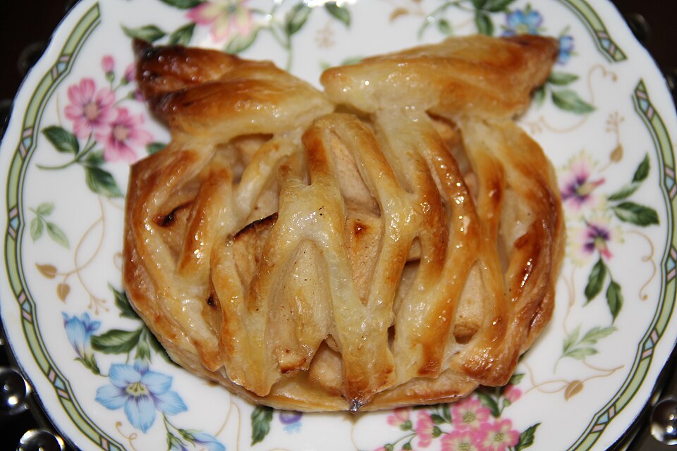 A slice of Greek milopita apple phyllo pie showing layered crisp pastry