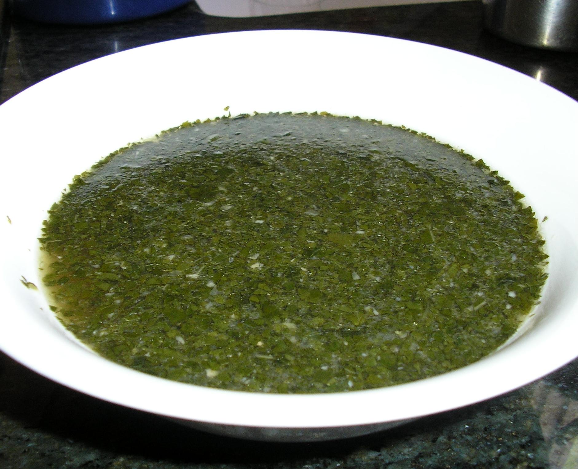 A pot of Cypriot molehiya, jute mallow leaves stewed with chicken and lemon