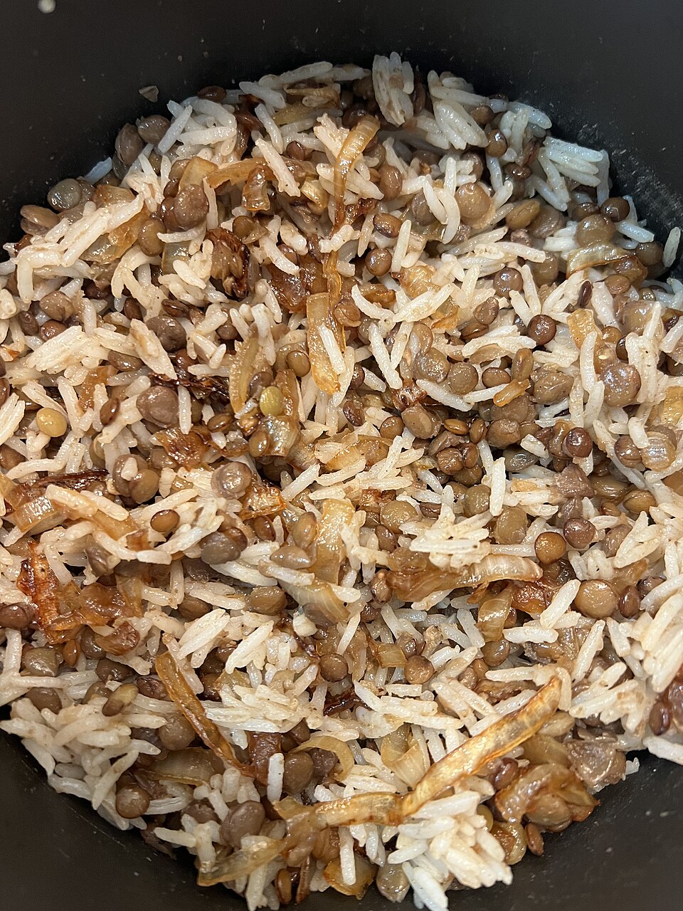 A plate of Cypriot moutzentra, lentils and rice topped with caramelised onions