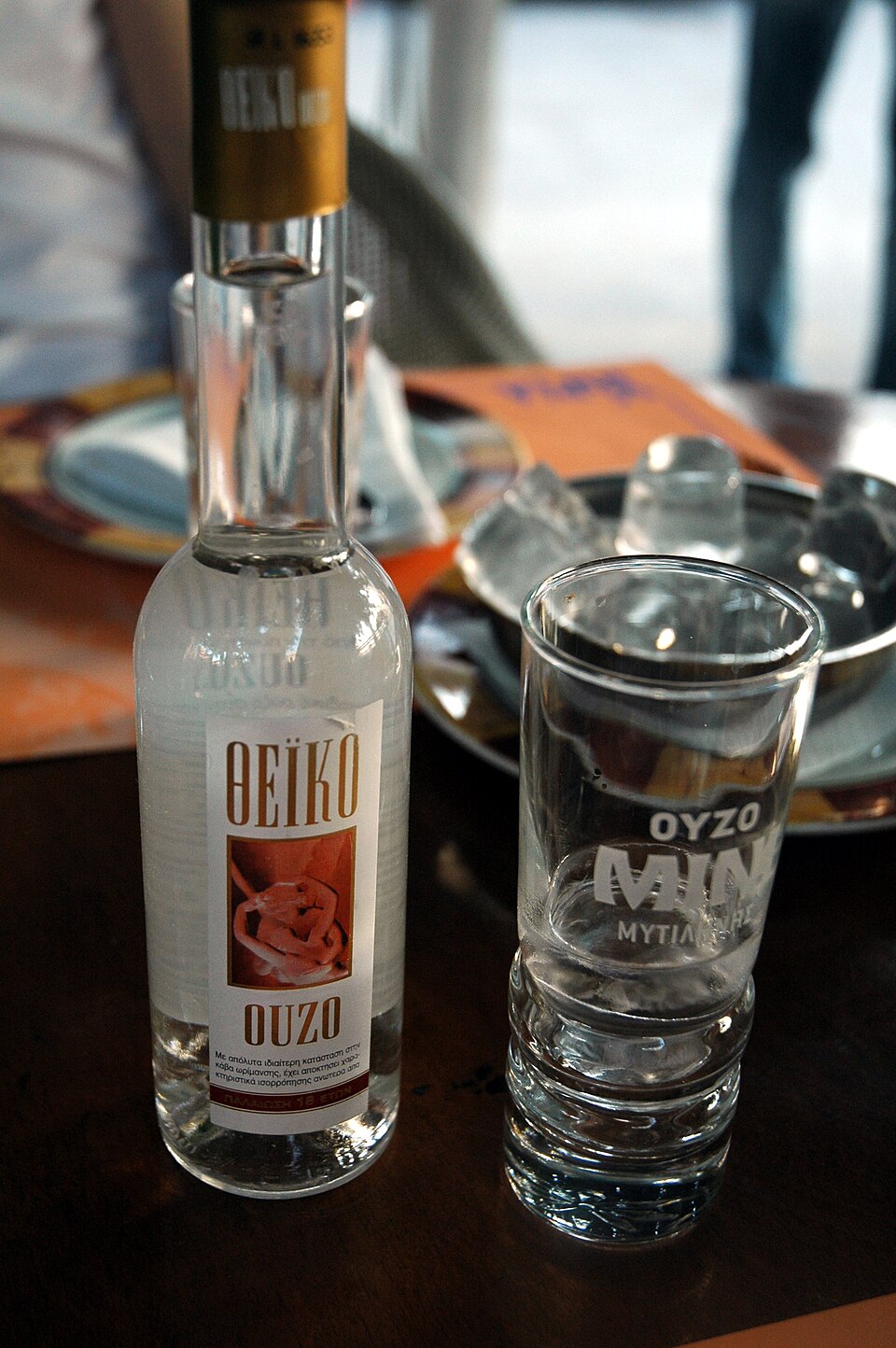 A glass of ouzo turned milky white with water and ice