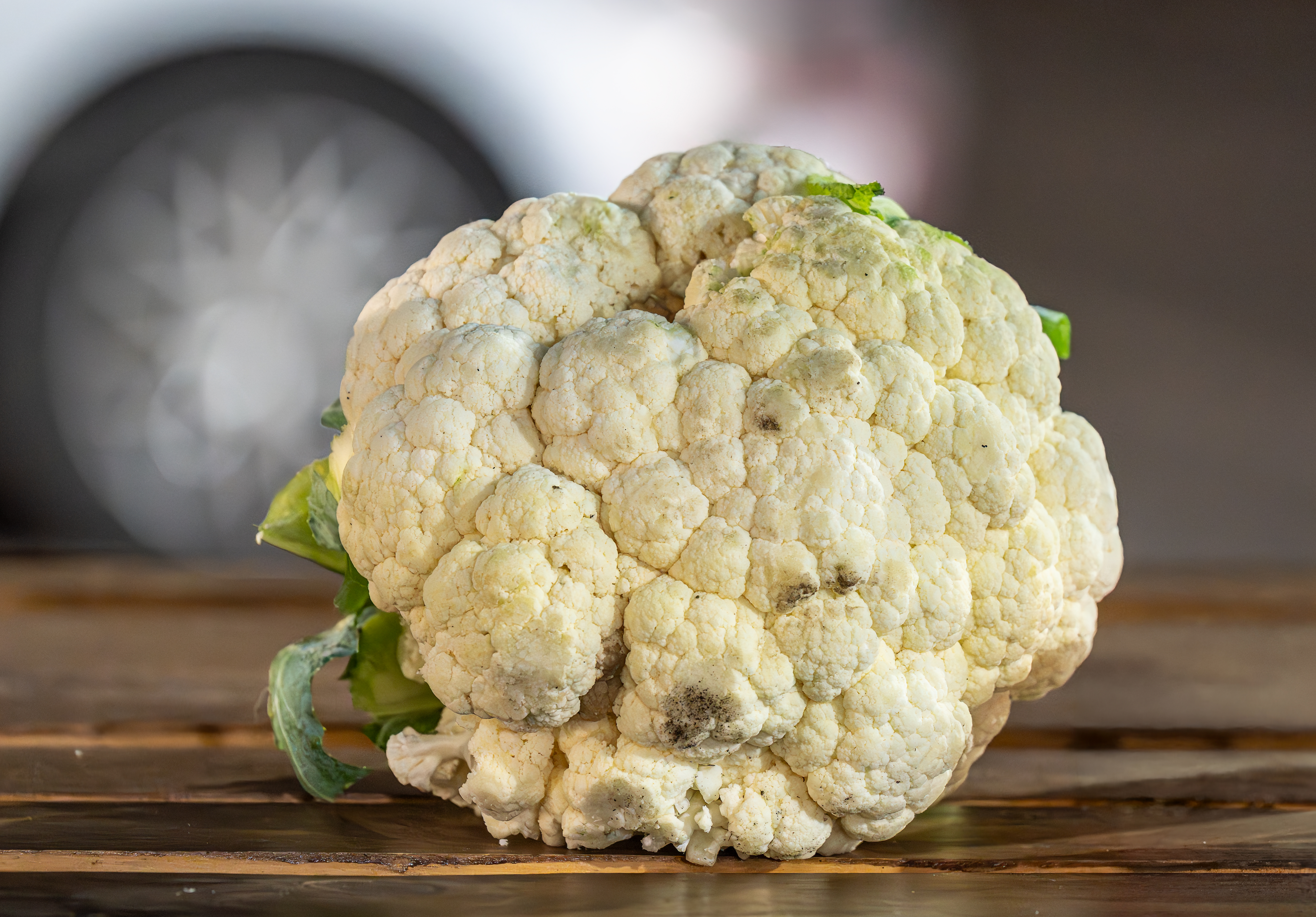 A head of cauliflower with its outer leaves still on