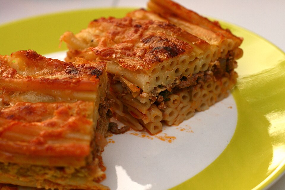 A slice of pastitsio showing distinct layers of pasta, meat sauce and golden bechamel