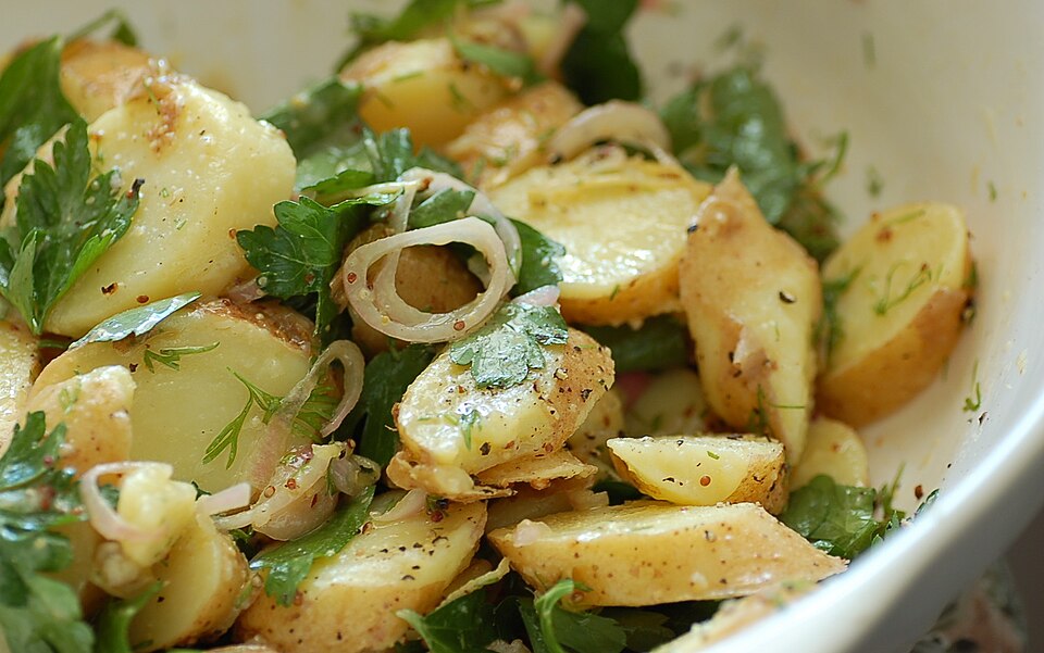 A bowl of Greek patatosalata potato salad with red onion and herbs