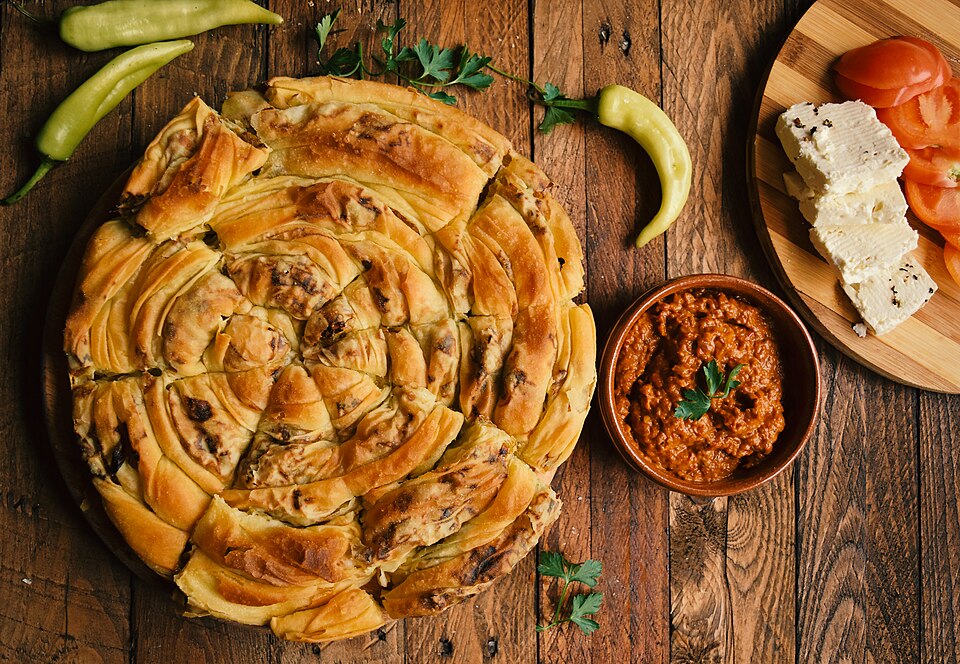 A slice of Greek prasopita leek and feta pie showing layered phyllo