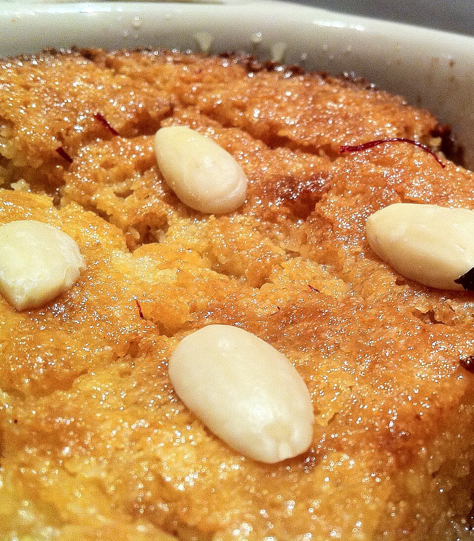 A slice of Greek ravani semolina syrup cake dusted with coconut