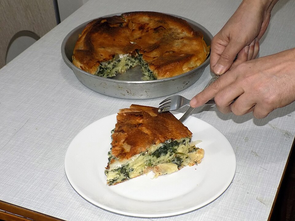 A slice of Greek spanakotyropita spinach and cheese pie