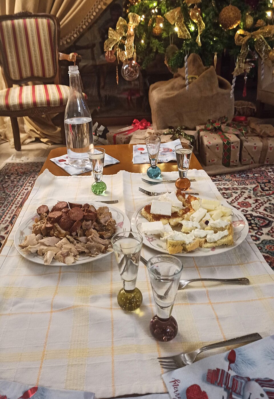 A small glass of Greek tsipouro with ice and a meze plate