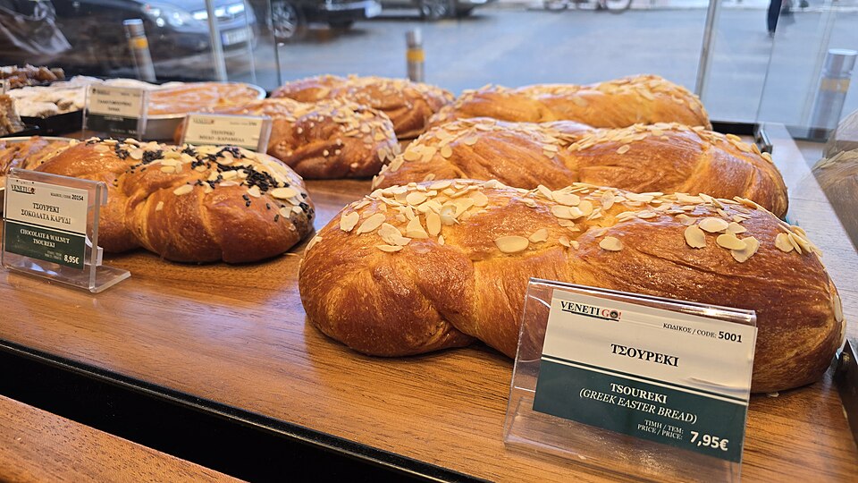 A golden braided Greek tsoureki Easter bread with a red egg tucked in